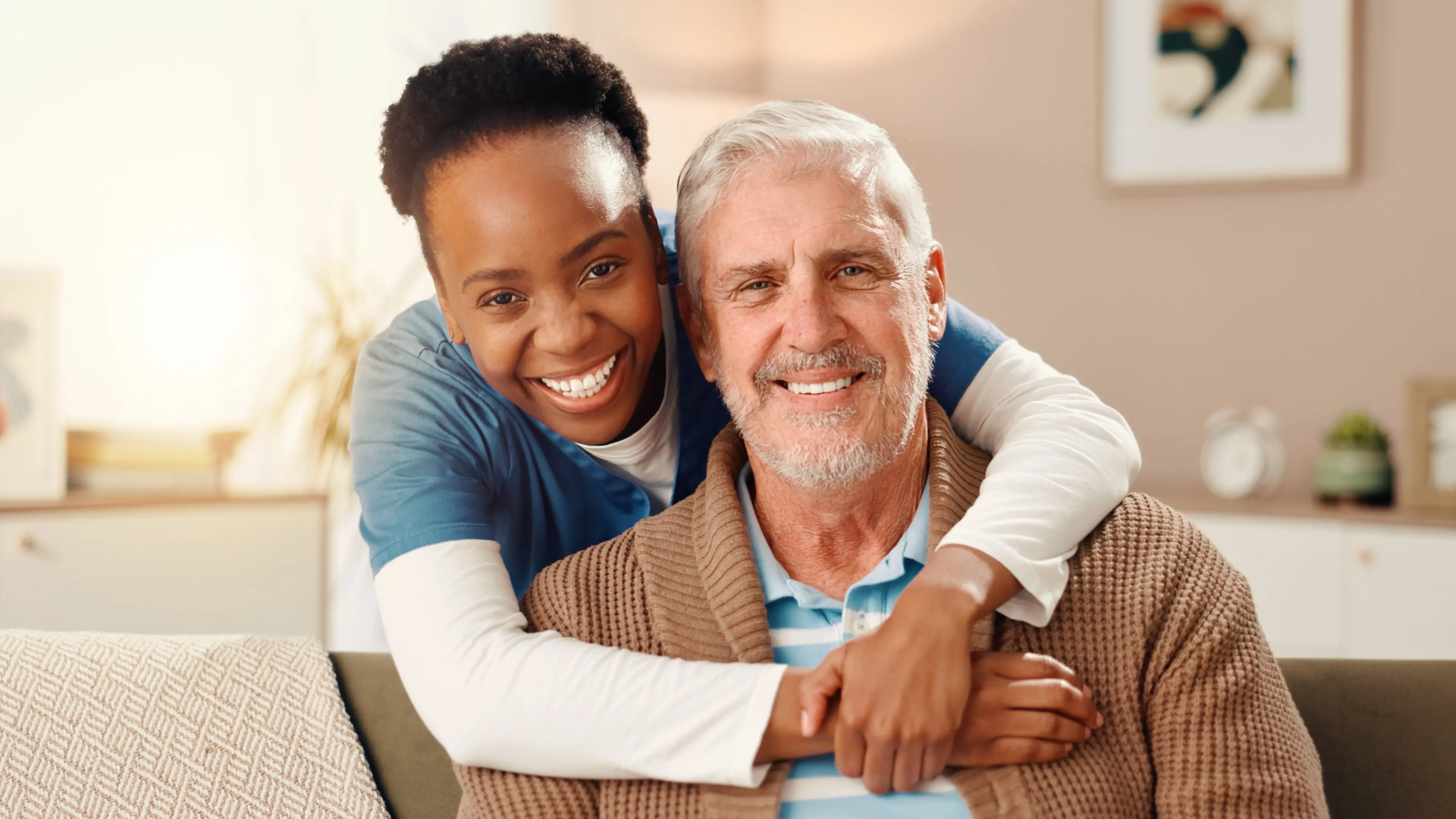 Happy nurse, portrait and hug with elderly patient at retirement house for assisted living or care. Woman, medical caregiver or smile with retired man or senior for private healthcare at old age home